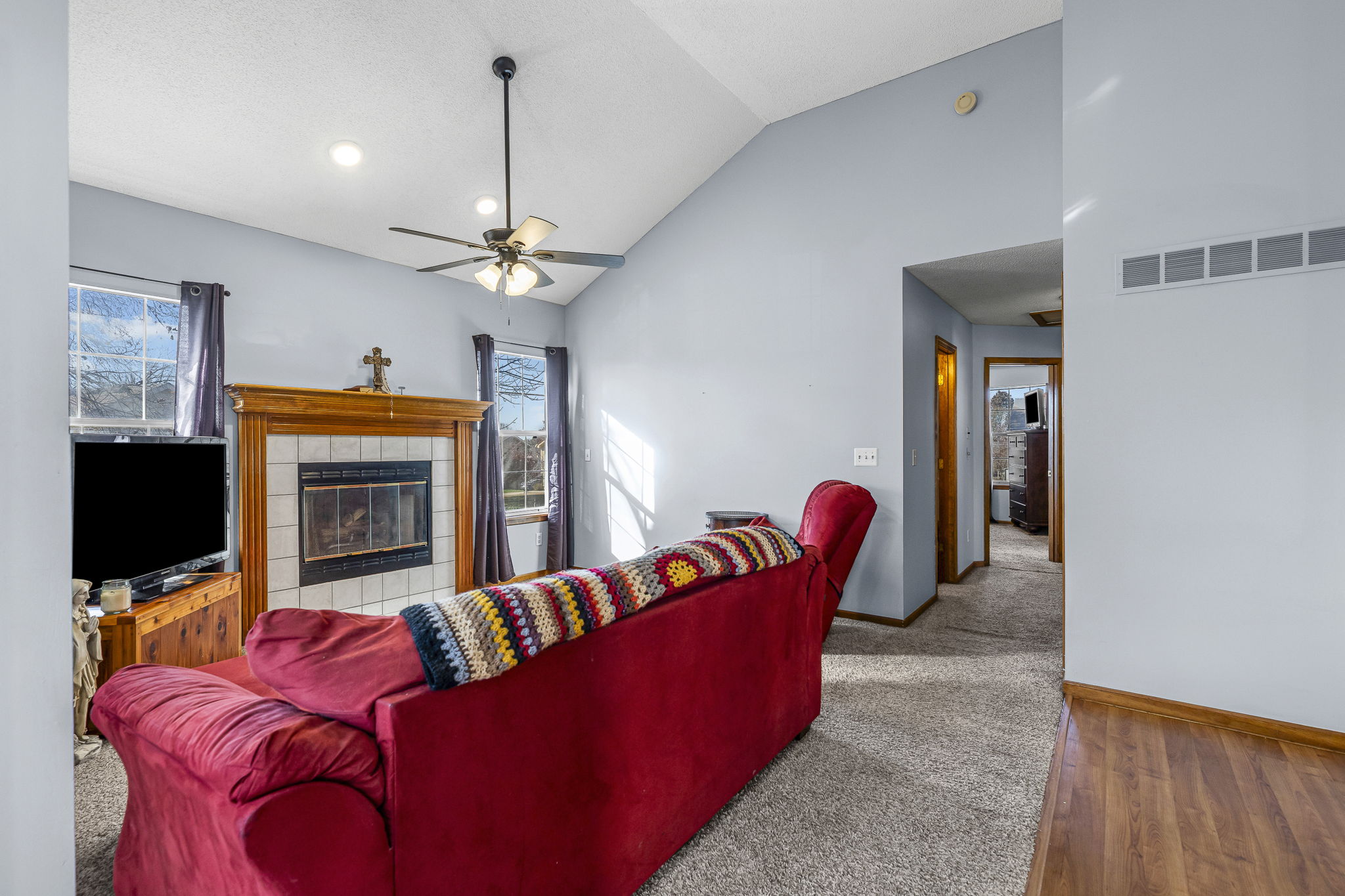 Living room with cozy fireplace and vaulted ceiling