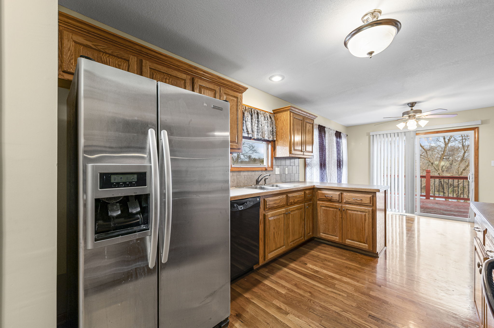 Kitchen with stainless appliances opening to the deck