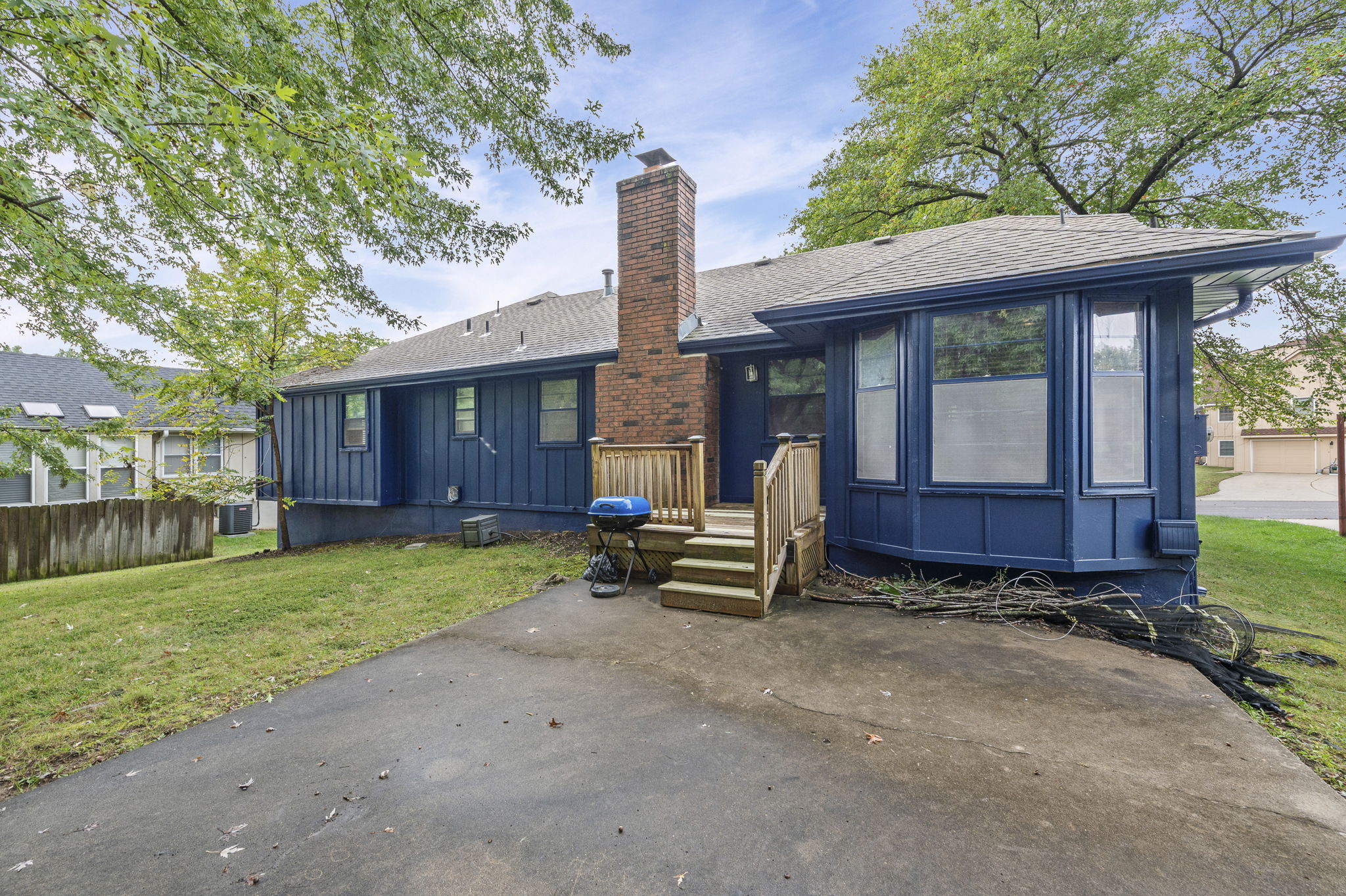 Back exterior with deck and mature, shaded yard