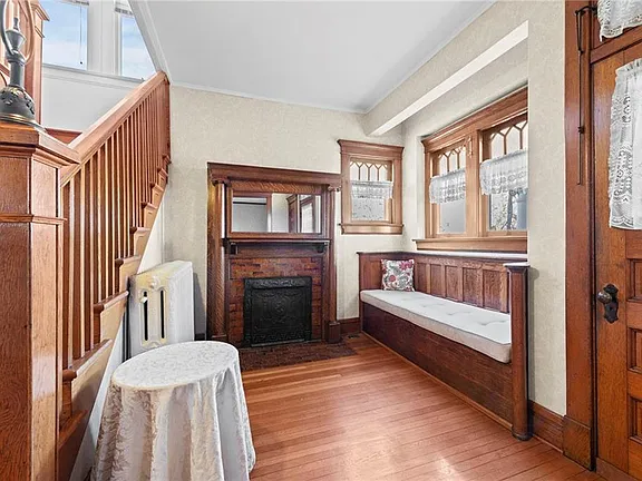 Foyer with original woodwork, decorative fireplace, and built-in calling bench