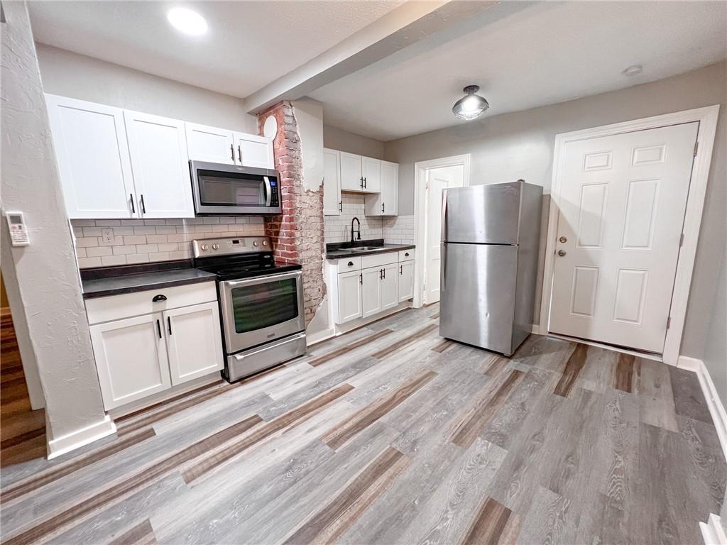 Renovated unit kitchen — stainless appliances and exposed brick
